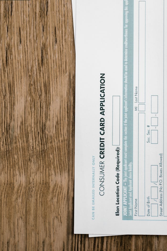 Close-up of a consumer credit card application form on a wooden surface, indicating financial paperwork.